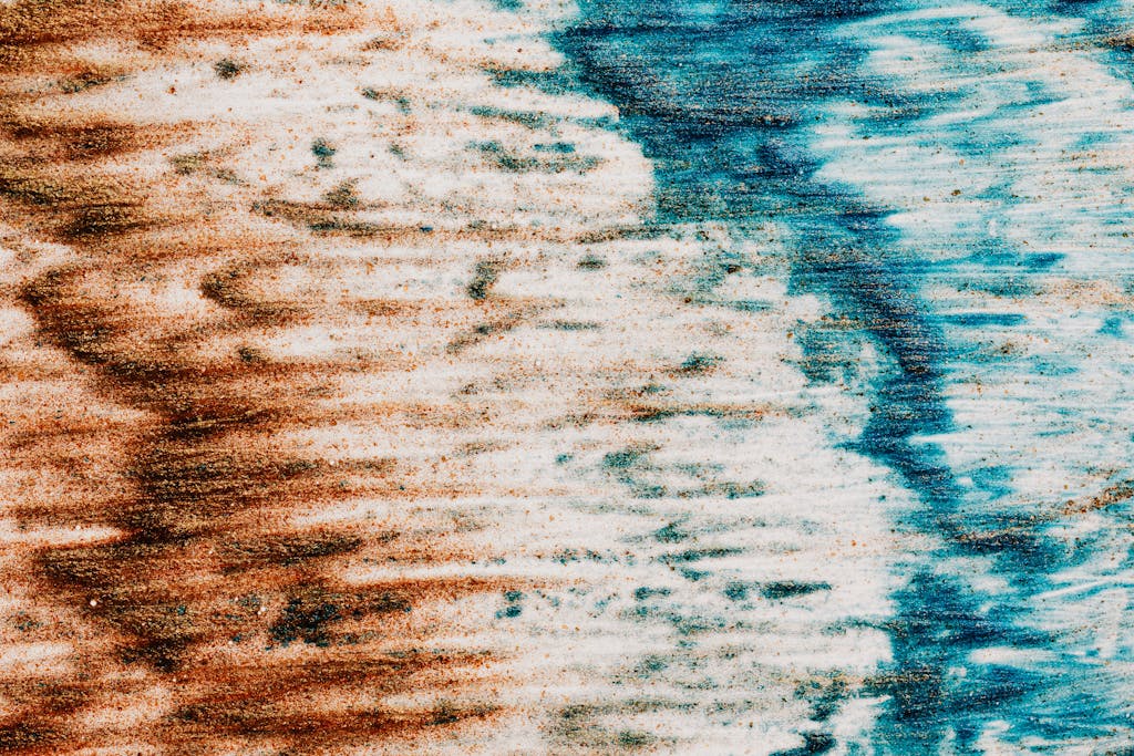 Abstract textured surface made of colorful paints of blue and brown colors on white background